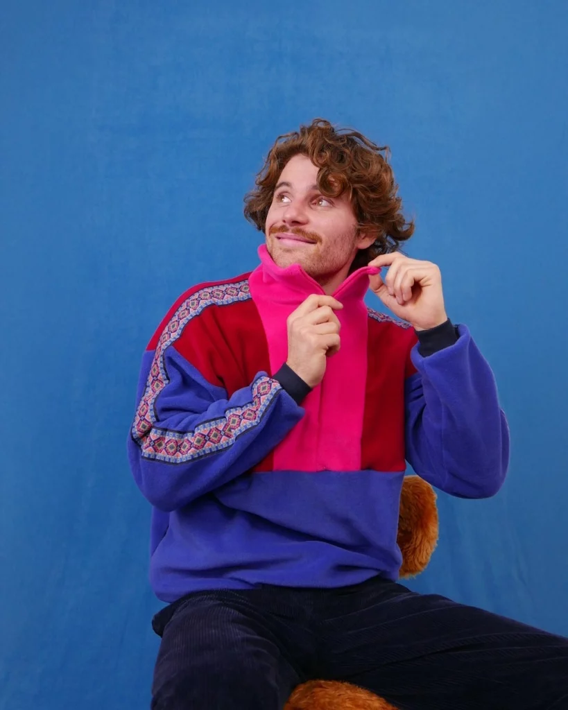 homme portant un pull polaire bleu rouge rose